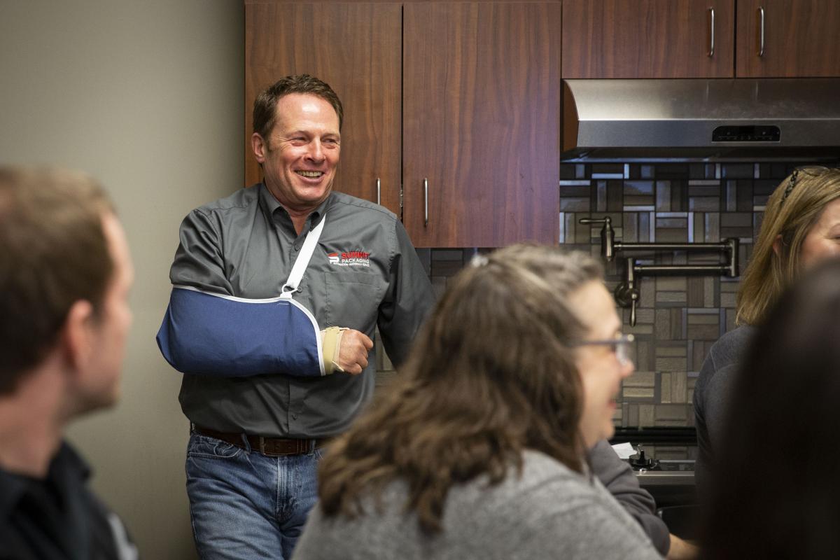 Man with sling smiling in Summit meeting